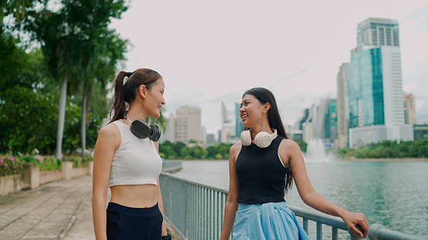 istock Young Asian women talking casually after running for exercise in a public park. 2237982571
