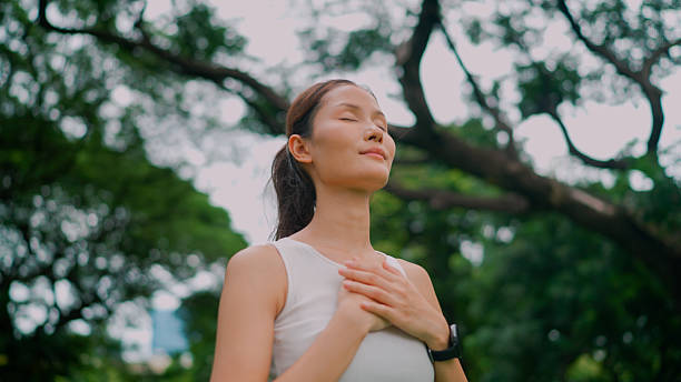 istock Young Asian woman taking in fresh air while going out for an exercise in a park. 2237983882