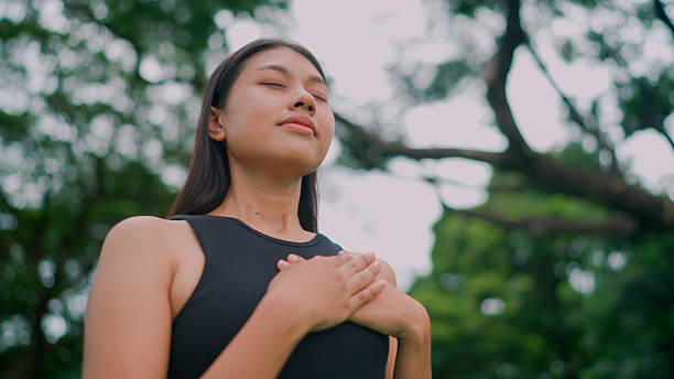 istock Young Asian woman taking in fresh air while going out for an exercise in a park. 2237983901