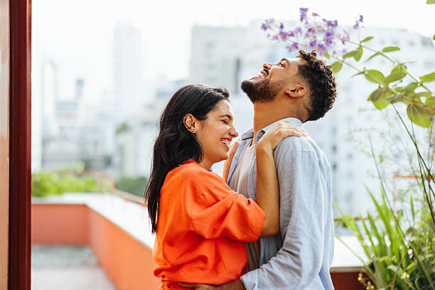 istock Young couple laughing together outdoors on a sunny day 2237984121