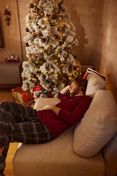 istock Exhausted man taking a nap during Christmas at home. 2237984621