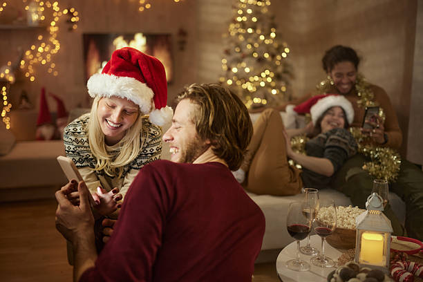 istock Happy couple using smart phone during Christmas gathering with their friends. 2237985006