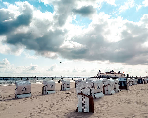 istock Beach chairs on sandy shore with pier and historic pavilion 2237985214
