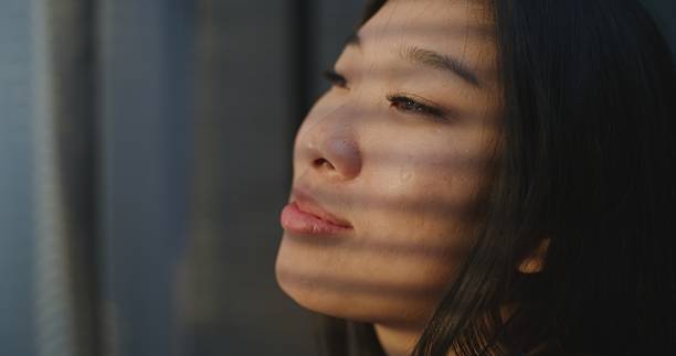 istock Young Woman Enjoys Warm Sunshine Falling on Face 2237985695