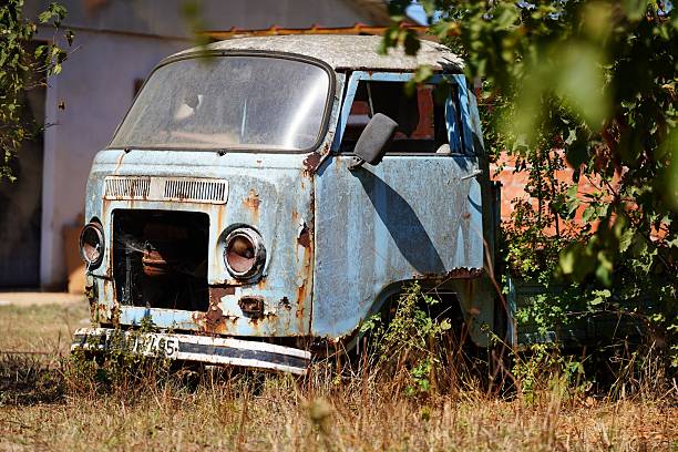 istock An old, rusty van was abandoned in a field, surrounded by overgrown plants under the bright sunlight 2237990335