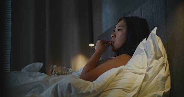 istock Before Sleeping, Girl in Bed Snacks in Front of TV 2237990652