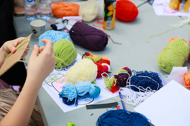 Child engaged in colorful yarn craft project at creative workshop. May 31, 2024 Balti Moldova.