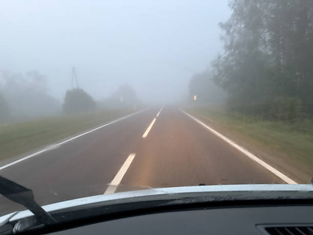 istock A view from the driver's seat looking through a car windshield covered in condensation, fogging and rain streaks. The moisture blurs the outside scenery into abstract shapes of trees, post and house. 2237995968