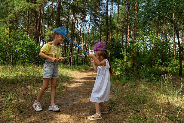 istock Two little girls catching insects with nets in forest 2237996181