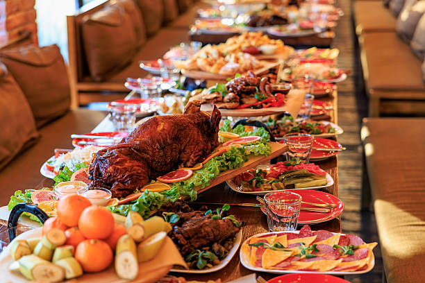 Lavish feast table with roasted meat and fresh fruits.