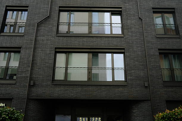 Building facade with windows on dark gray brick wall, building exterior, architecture