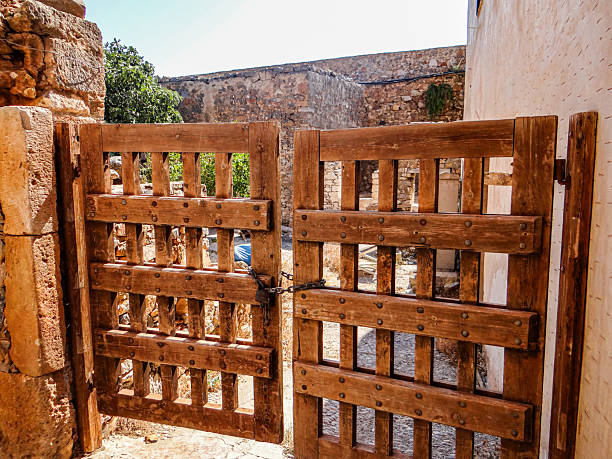 Spinalonga, Crete, Greece – 19 July 2014: A restored wooden gate inside the Venetian fortress on the island of Spinalonga, located in the Gulf of Elounda in northeastern Crete. The fortress, built in the 16th century by the Venetians, later served as a leper colony until 1957. The preserved structures and gates reflect the island’s layered history as a strategic military outpost and a place of isolation.