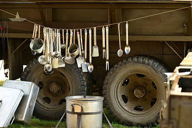 Liberation Camp : Showing part of vehicles and military equipment from World War II. Portable field kitchen with kitchen utensils, pots and pans.