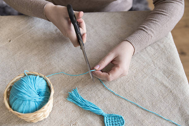 istock A woman cuts yarn with crochet, knitting, or macrame scissors 2238003222