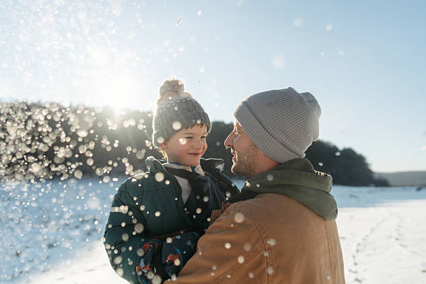 Photo of a father and son, having precious moments on a snowy day they are spending outdoors, in nature