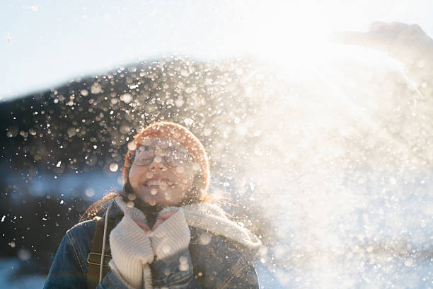 Photo of a young woman enjoys the nature covered in snow on a cold but sunny day