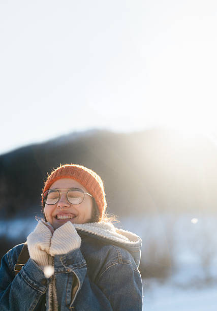 Photo of a young woman enjoys the nature covered in snow on a cold but sunny day
