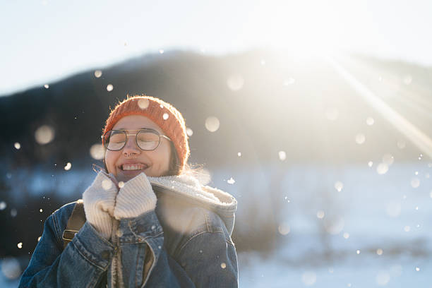 Photo of a young woman enjoys the nature covered in snow on a cold but sunny day