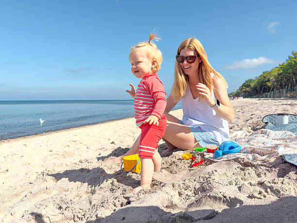 istock Mother and daughter playing with molds on the beach. 2238007709