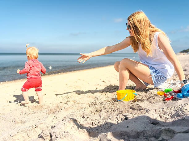 istock Mother and daughter playing with molds on the beach. 2238007711