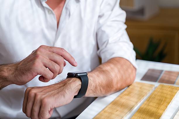 istock Man tapping smartwatch selecting wood samples for home renovation 2238007909