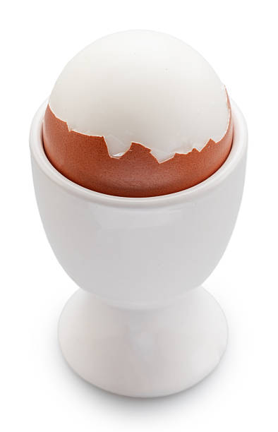 istock Boiled partly peeled chicken egg in the egg cup on white background. File contains clipping paths. 2238015437