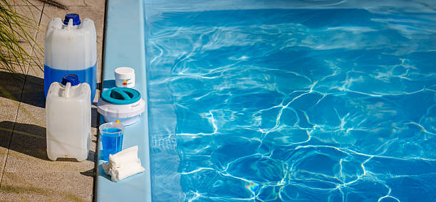 istock Poolside cleaning kit with blue chemical canisters, chlorine tablets, floating dispenser, measuring cup and sanitizer supplies for swimming pool maintenance 2238017127