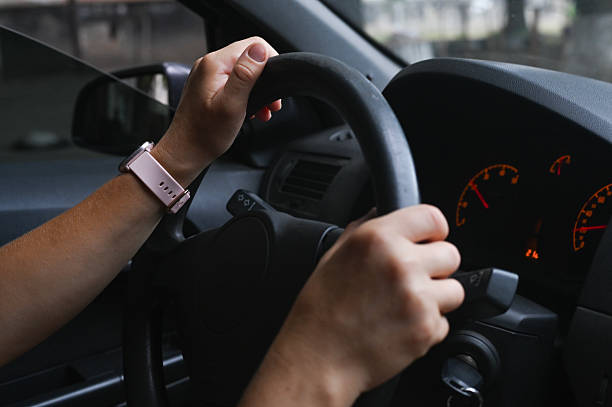 istock womens hands on steering wheel grip, showing focus and control. 2238017544