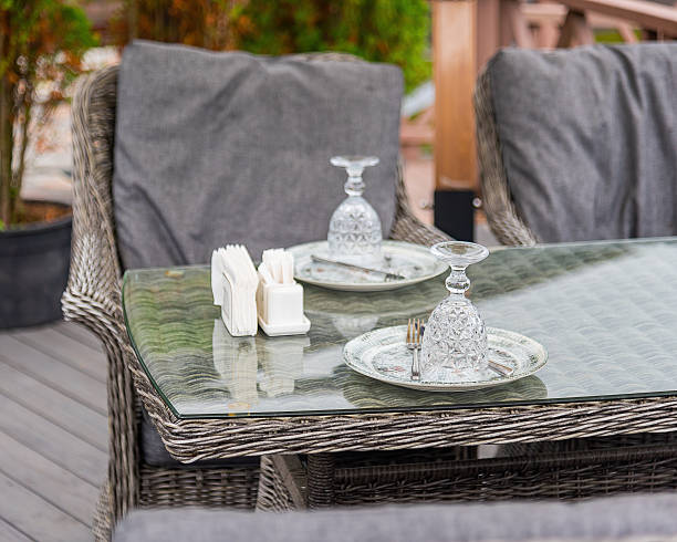istock table setting scene. A wicker chair and a table made of natural materials feel warm and simple. On the table neatly arranged clean cutlery, shiny glasses . concept - neatness and waiting for guests. 2238025844