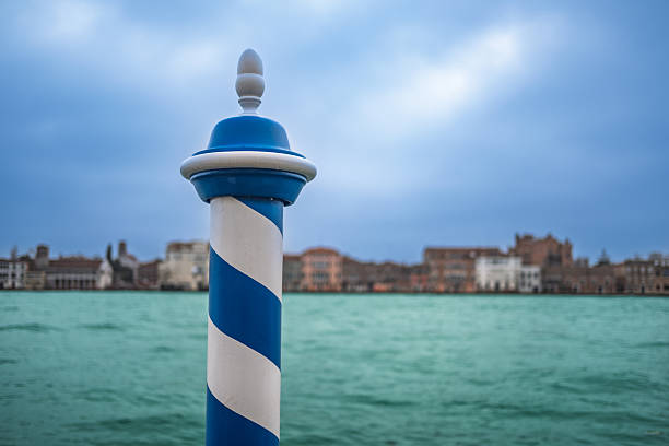 Venice, Italy - May 18, 2015: A blue and white police (Polizia) motor boat parked at a dock with blue poles on the Grand Canal in Venice, Italy. 