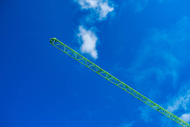 green arrow cargo construction crane on background of sky