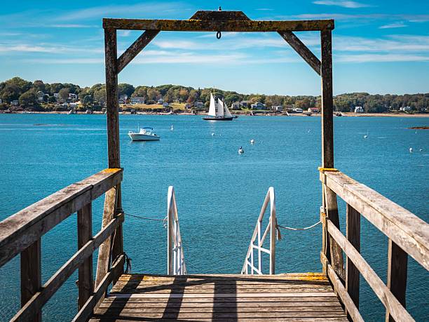 Bar Harbor, Maine, USA - October 2, 2021: A wide-angle view of a commercial pier at shore of Frenchman Bay on a sunny Autumn morning.