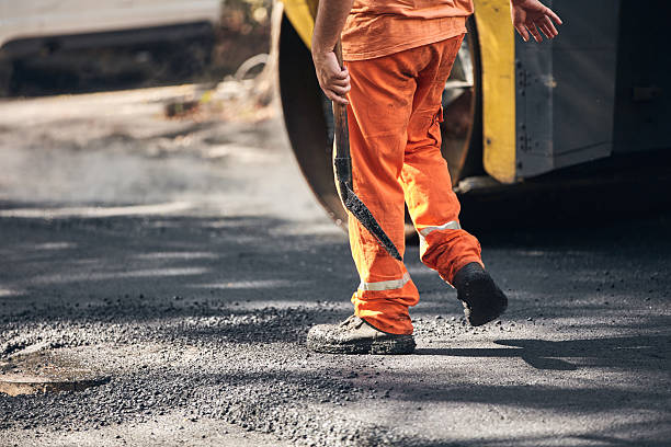 istock Construction worker working on a new asphalt layer on a public street. 2238030692