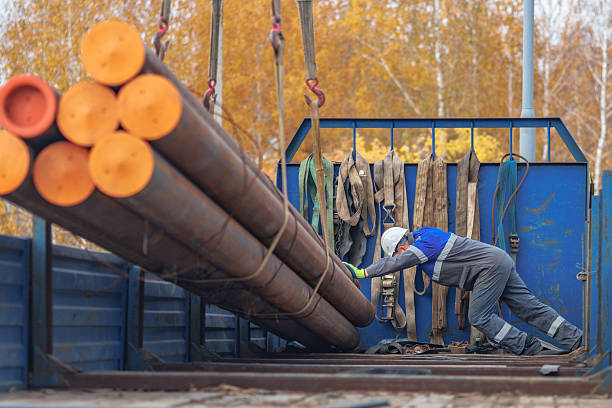 istock Worker Loading Steel Pipes at Construction Site in Autumn 2238030720