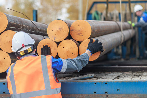 istock Construction Workers Handling Steel Pipes on a Truck 2238030762