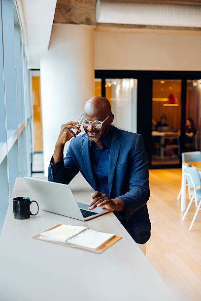 istock Professional man working on laptop and talking on the phone in an office 2238030895