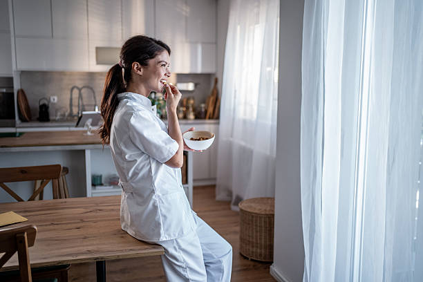 istock Young nurse enjoying relaxing break at home kitchen 2238033519