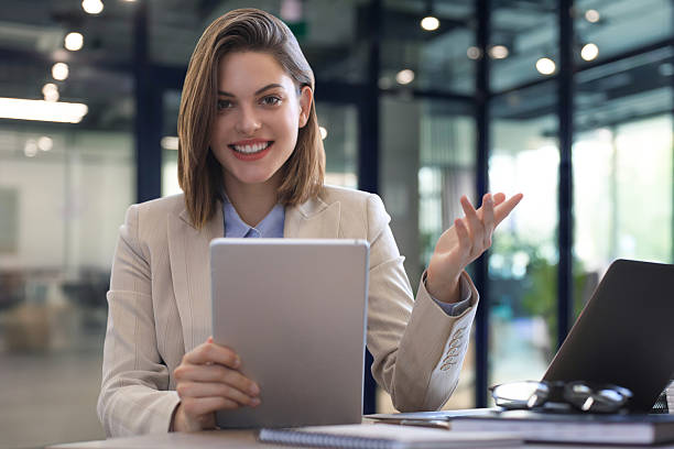 istock Attractive smiling woman working on a tablet in modern office. 2238039065