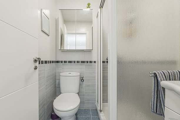istock A small bathroom with a small hanging cabinet with a mirror, a white wooden tea cabinet with a sink and a shower cabin with glass screens 2238043994