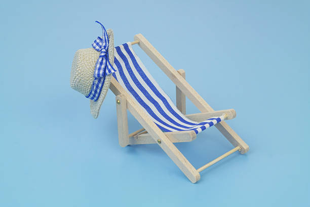 istock Blue beach chair with hat on blue background. 2238044380
