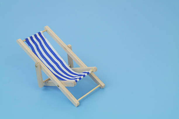 Blue beach chair on blue background. Copy space for text. Travel and vacation concept.