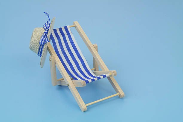 istock Blue beach chair with hat on blue background. 2238044468