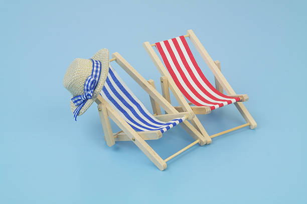 istock Blue and red beach chairs with hat on blue background. 2238044959