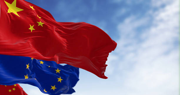istock China and EU flags wave together against blue sky, symbolizing international relations 2238046645