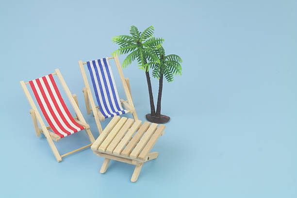 Yellow tropical palm tree and lounge chairs