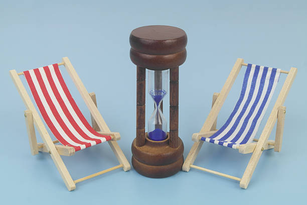 istock Blue and red beach chairs with hourglass on blue background. 2238048496