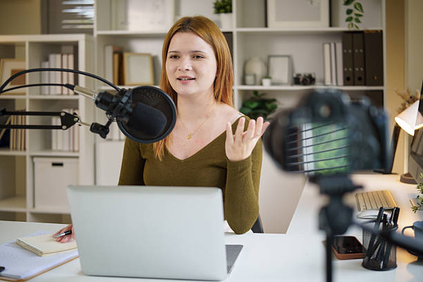 istock Confident young woman recording a podcast, talking into a microphone in a home studio. 2238048867
