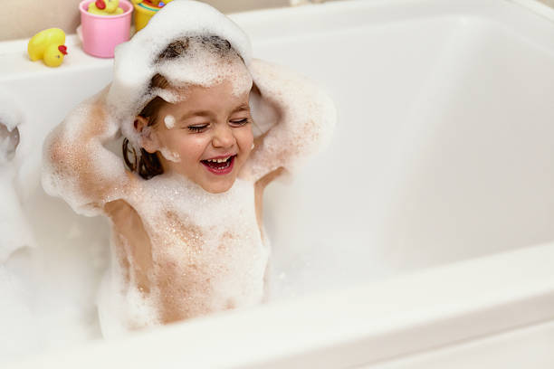 Smiling little girl enjoying a relaxing bubble bath.