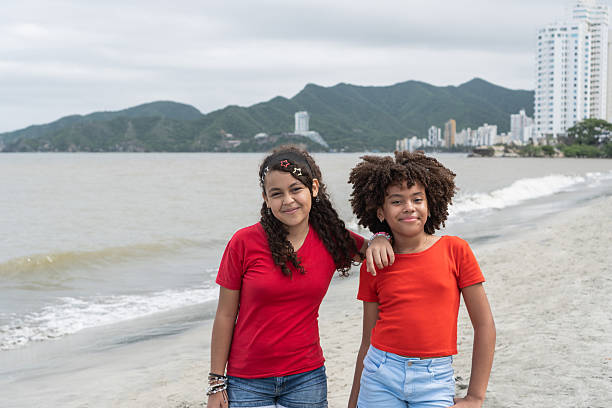 Two twin teenage sisters smiling at camera