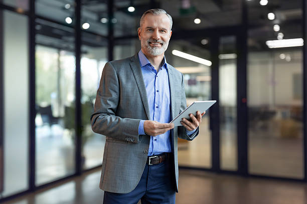 istock Smiling handsome businessman manager standing in office with tablet computer 2238054173